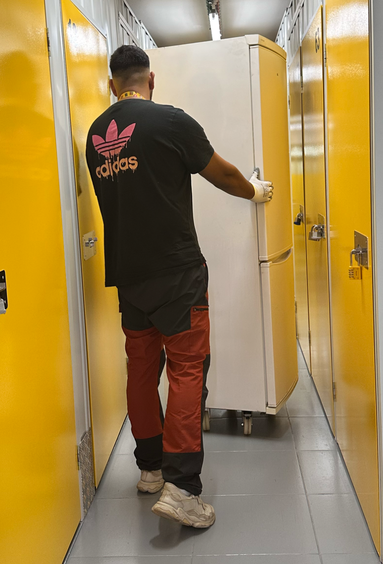 Recogida de electrodomésticos a domicilio - Servicio rápido y profesional Hombre con uniforme de trabajo frente a electrodomésticos usados para servicio de recogida y reciclaje en domicilio